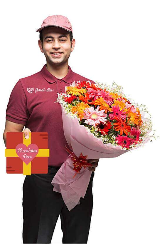 A delivery person holding up flowers at the front door of a home.